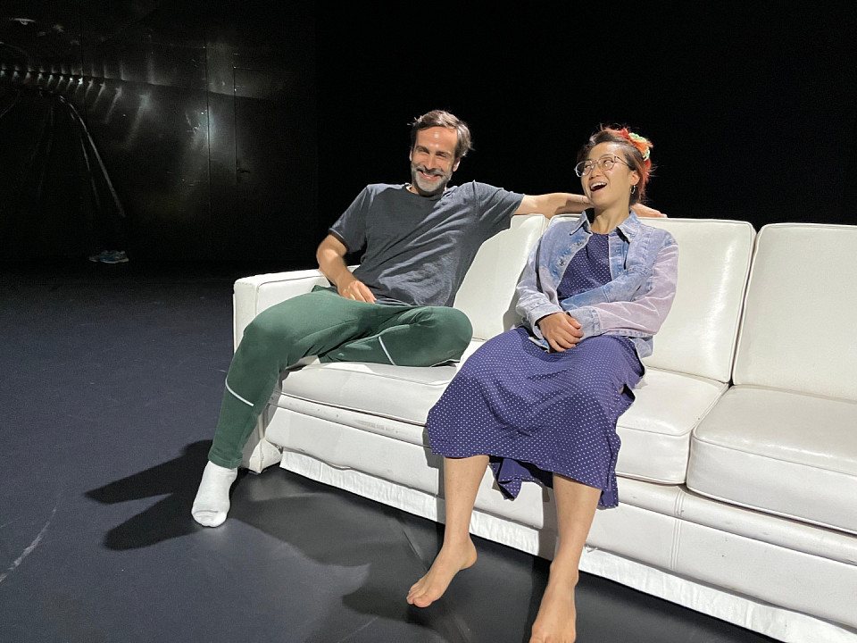 Die Stimmung ist gut bei Pin-Chen Hsu und Borys Jaźnicki auf der kühlen Ledercouch. Sie stand im Sozialraum des Tanzensembles, bevor es zum Bühnenbild gekrönt wurde. Was im täglichen Leben vor allem Geschmackssache ist (weißes Ledermöbel), eignet sich auf der Bühne hervorragend, um unterschiedliche Farbstimmungen  im Licht zu reflektieren.